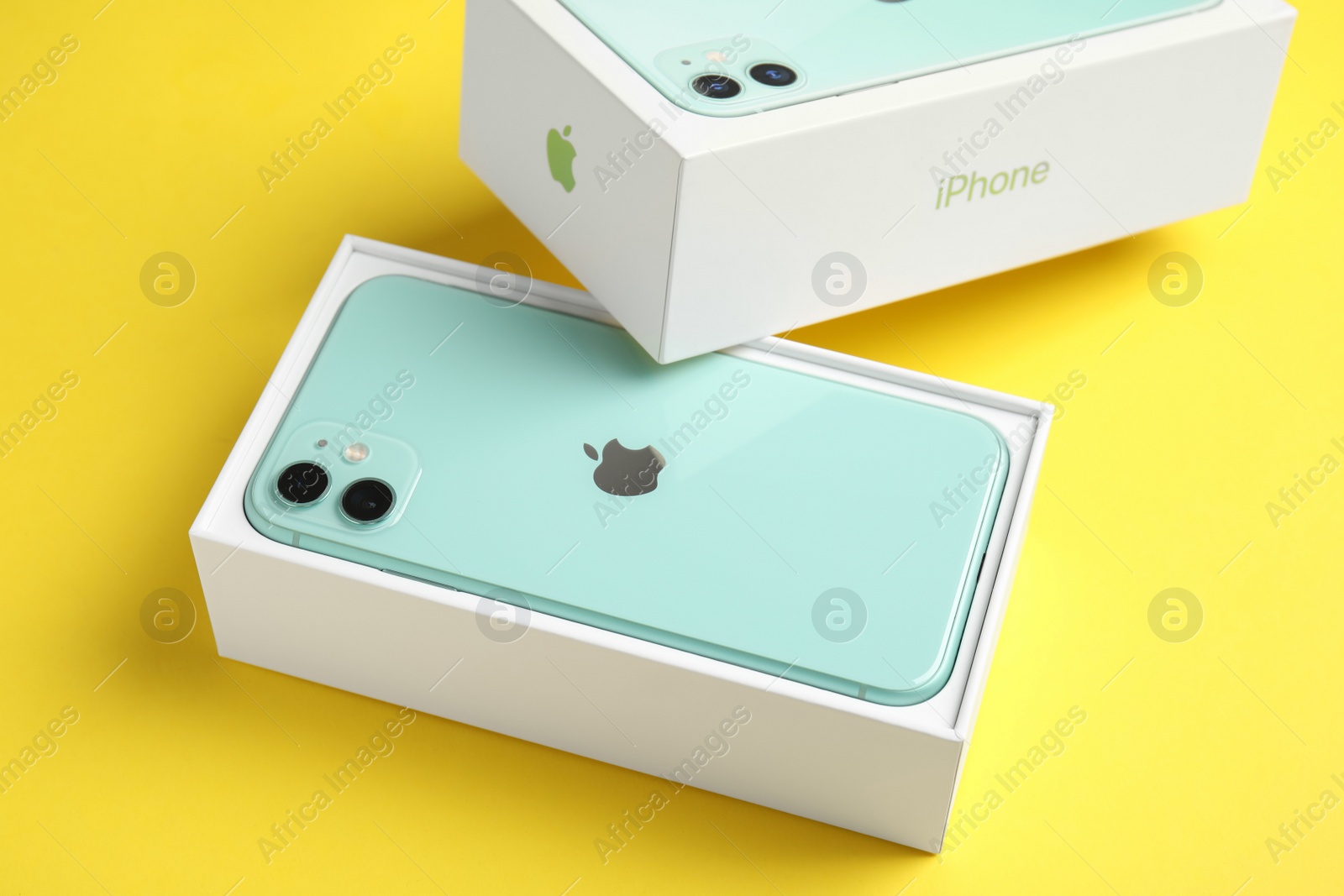 Photo of MYKOLAIV, UKRAINE - JULY 10, 2020: New modern Iphone 11 Green in original box on yellow background