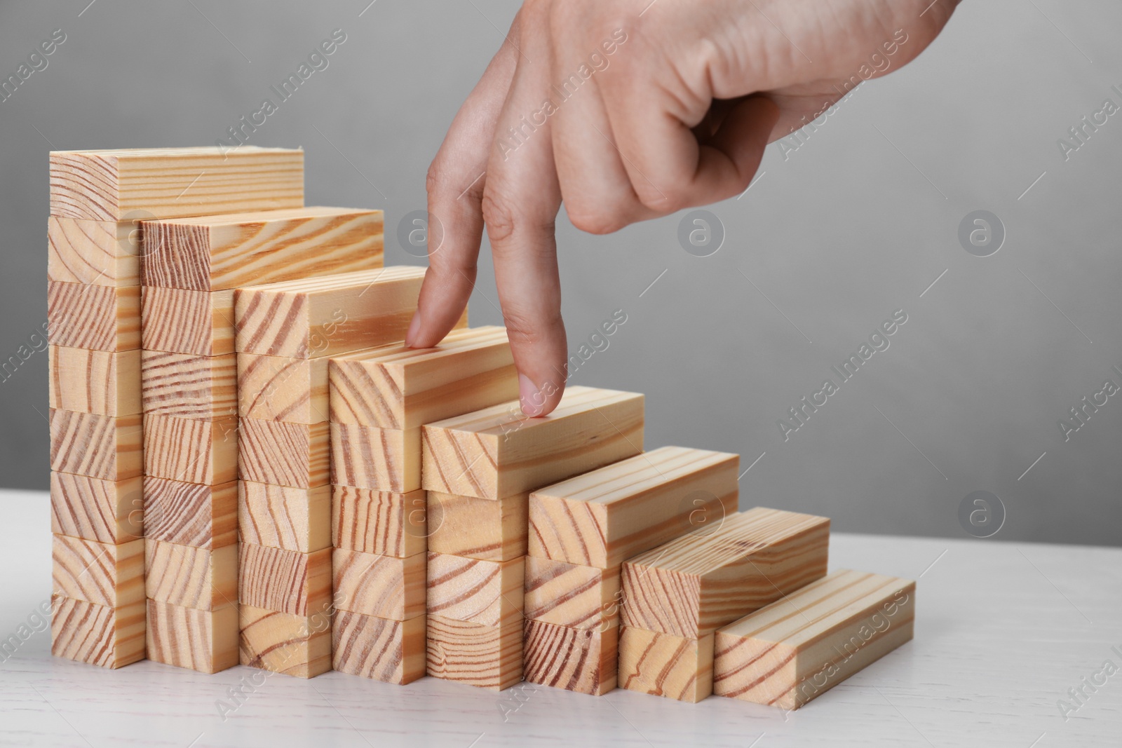 Photo of Woman imitating stepping up on wooden stairs with her fingers, closeup. Career ladder