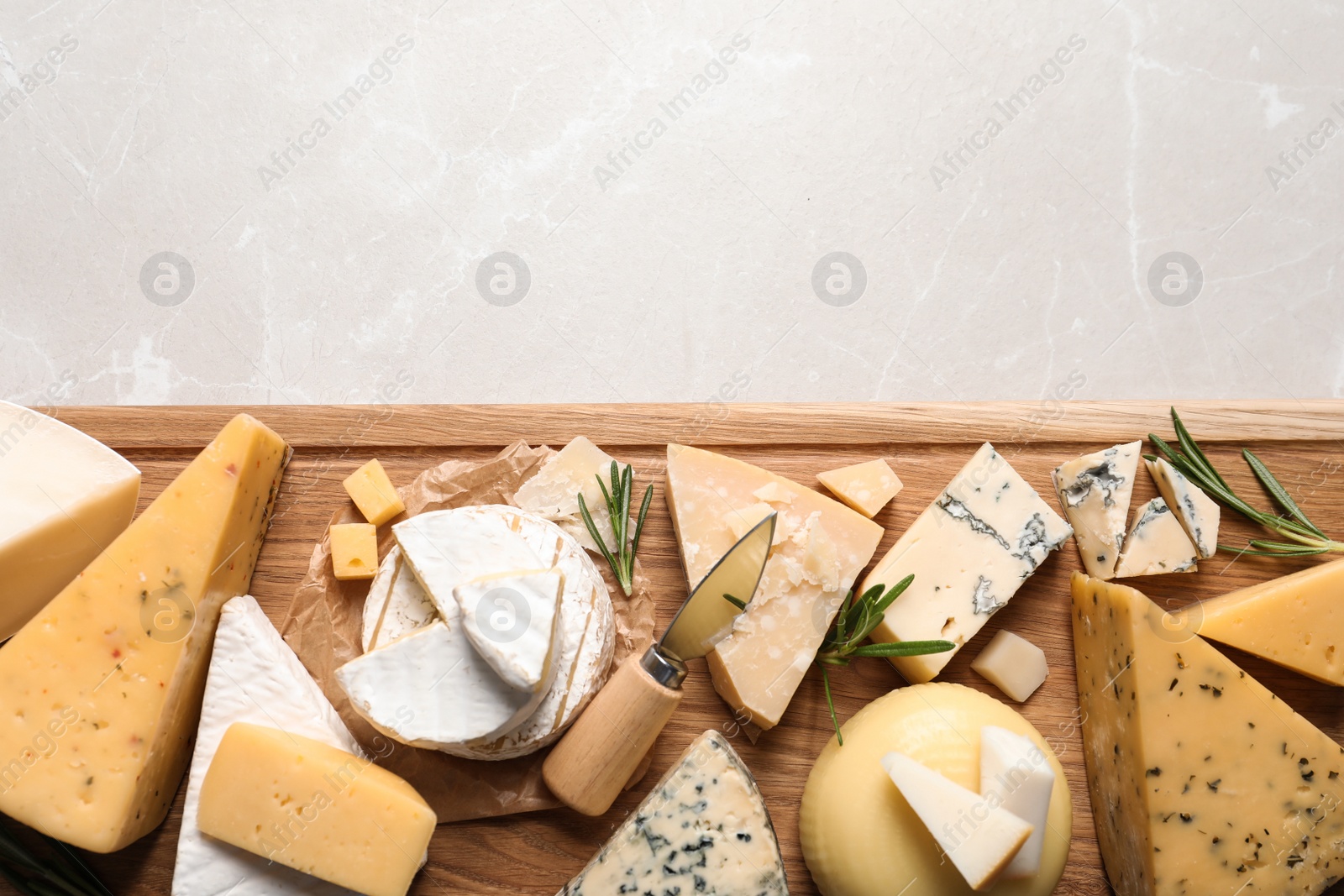 Photo of Different delicious cheeses served on grey table, top view. Space for text