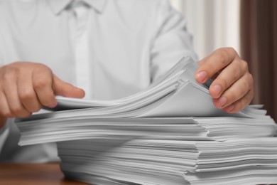 Man stacking documents in office, closeup view
