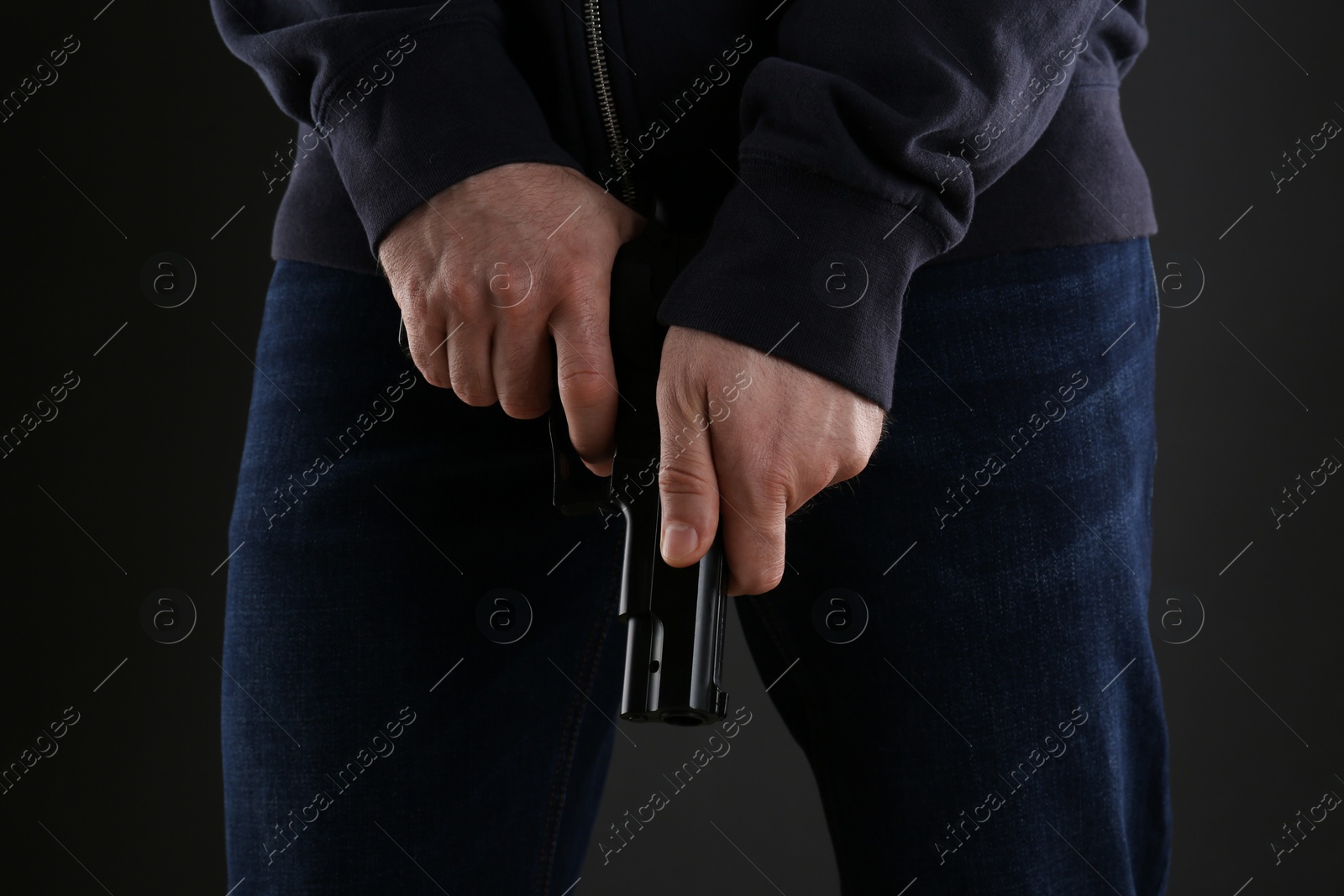 Photo of Man reloading gun on black background, closeup
