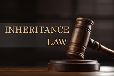 Image of Phrase Inheritance law and wooden gavel on table against blurred background, closeup