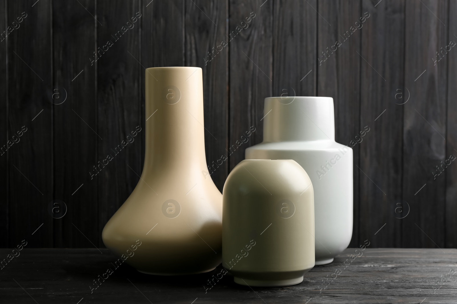 Photo of Stylish ceramic vases on black wooden table