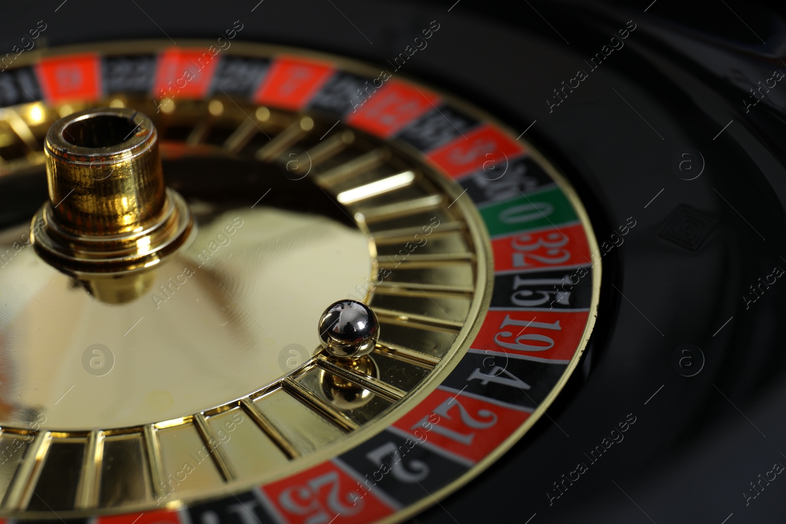 Photo of Roulette wheel with ball, closeup. Casino game