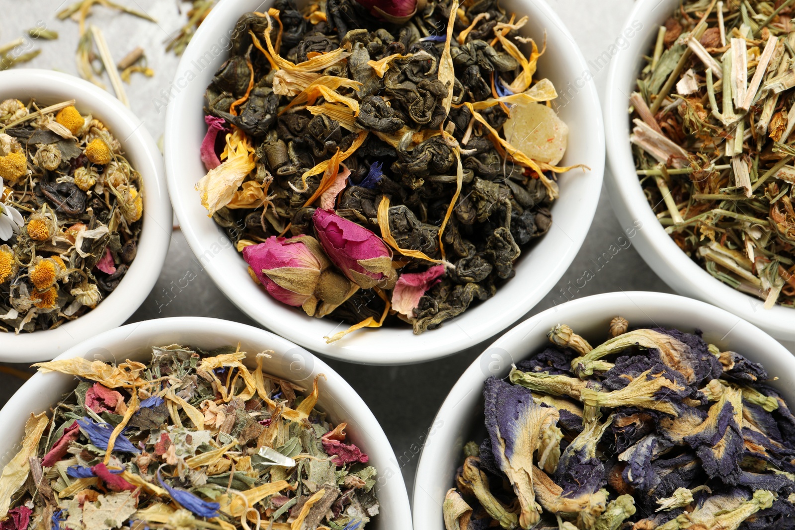 Photo of Flat lay composition with different dry teas on light grey table