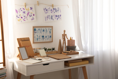 Photo of Stylish room interior with creative workplace near white wall