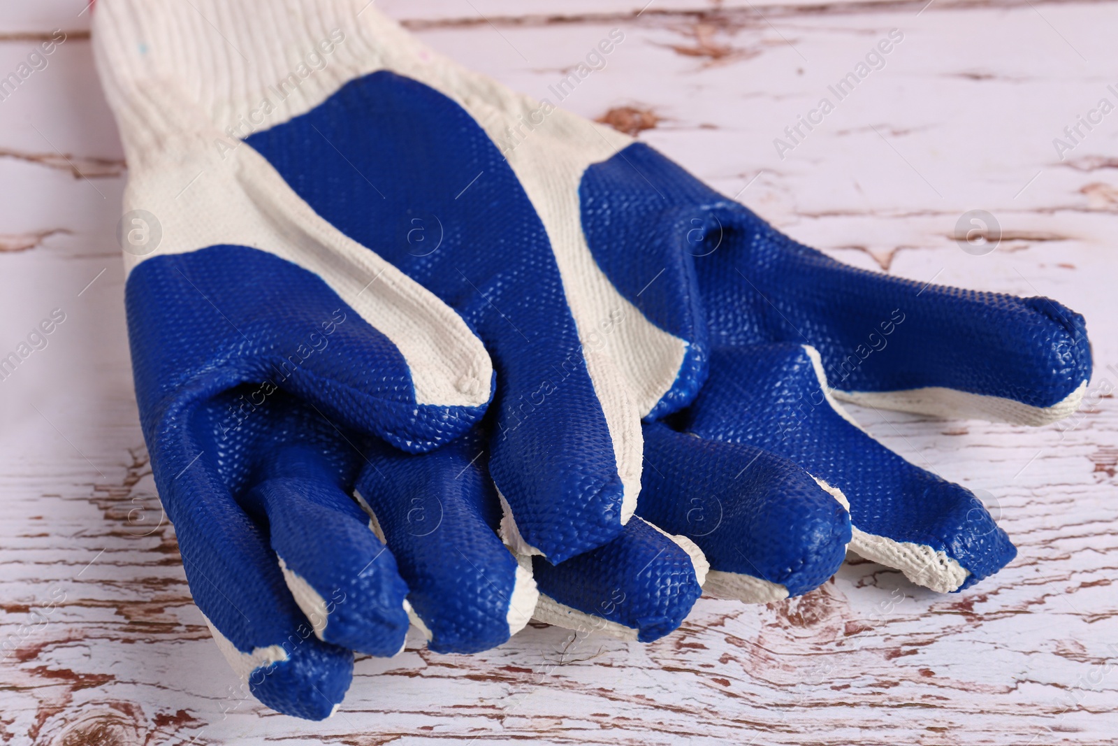 Photo of Gardening gloves on white wooden table, closeup
