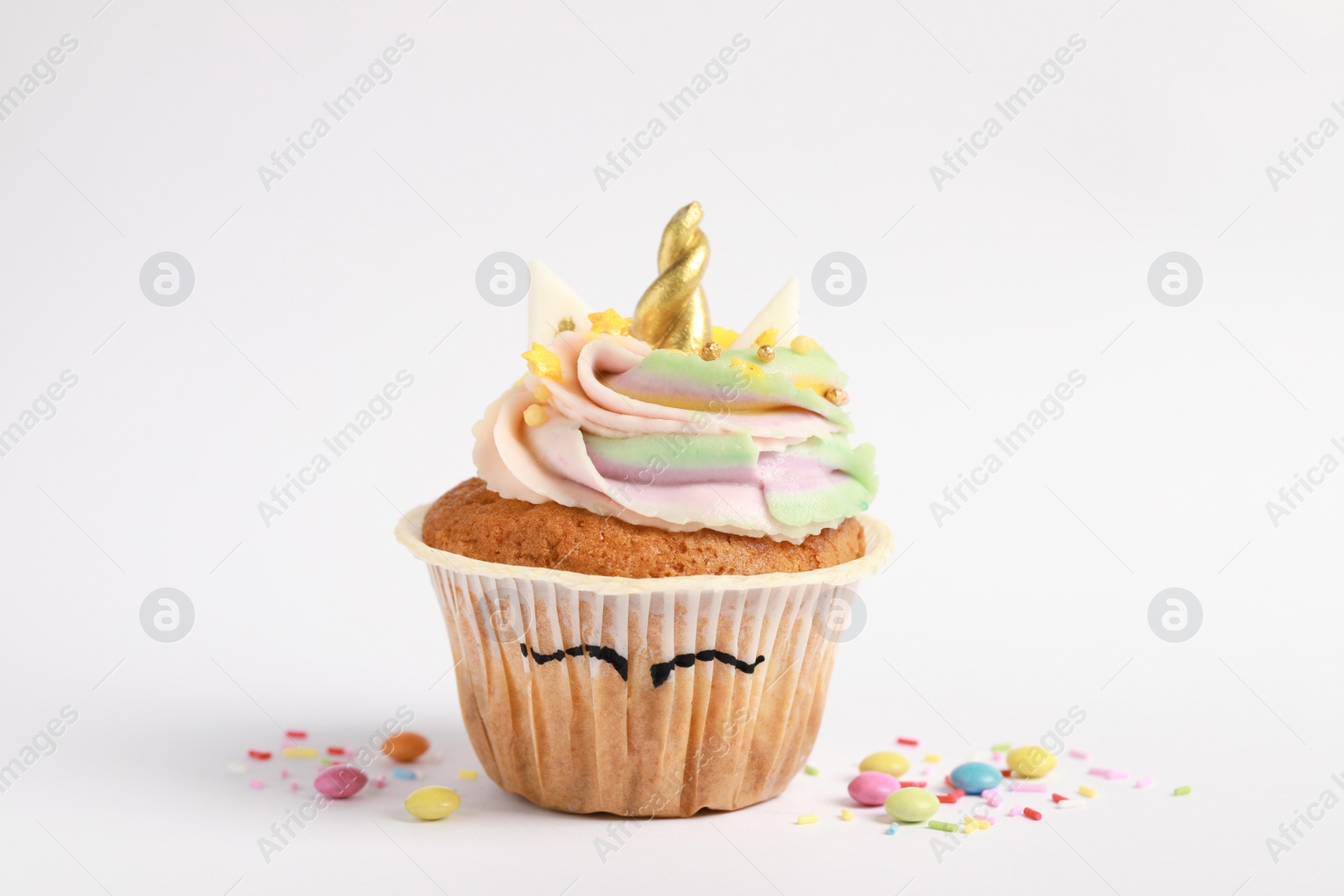 Photo of Cute sweet unicorn cupcake on white background