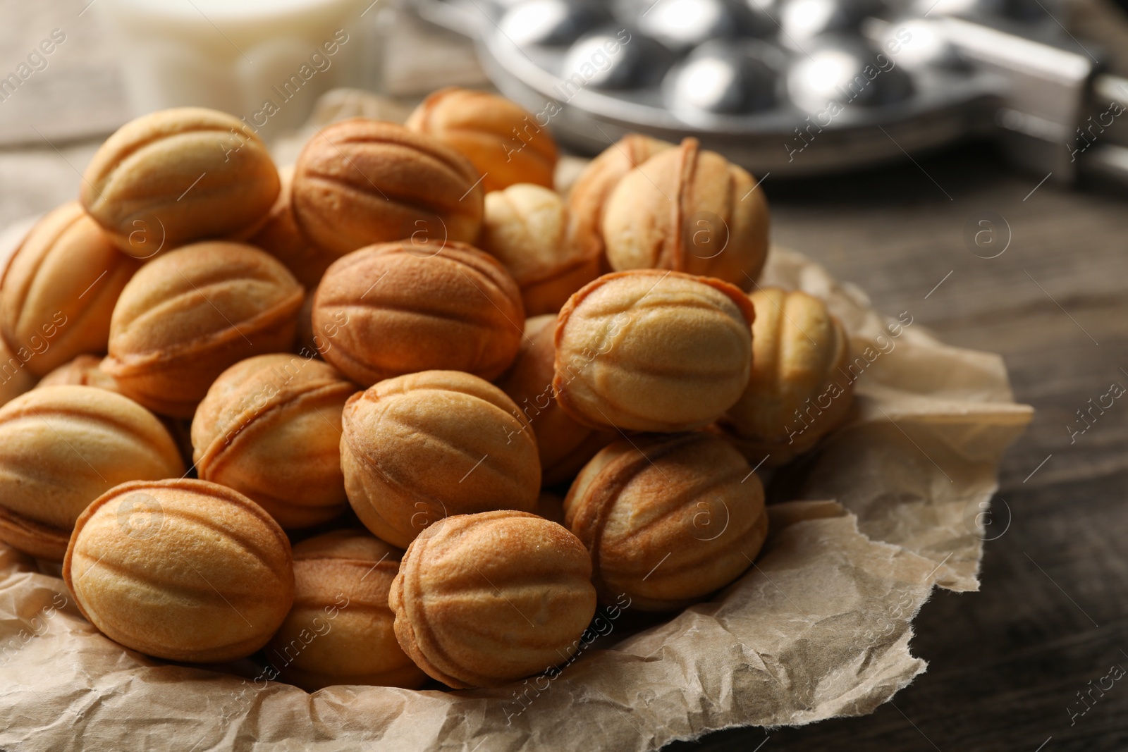 Photo of Bowl of delicious nut shaped cookies on wooden table, closeup