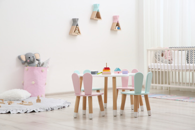 Cute baby room interior with cot and little table