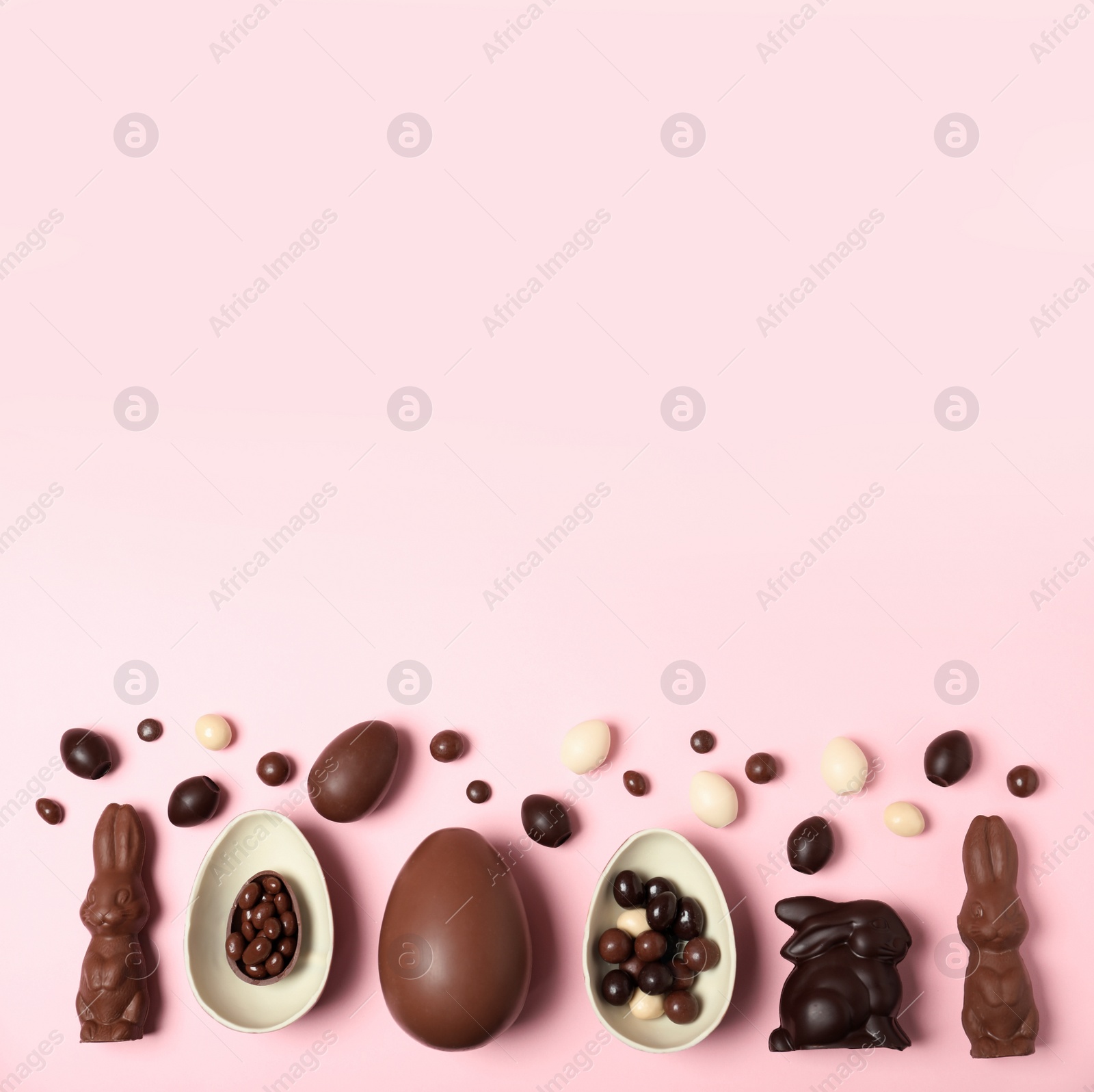 Photo of Flat lay composition with chocolate Easter eggs and space for text on color background