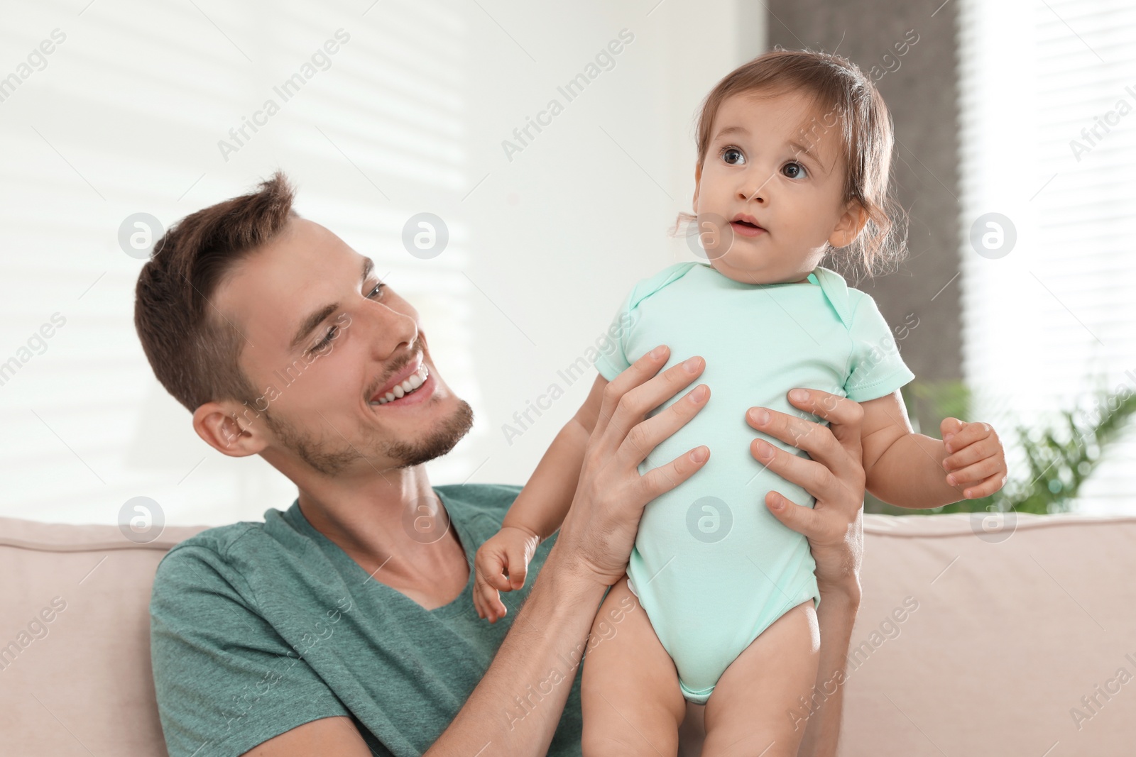 Photo of Father with adorable little baby at home. Happy family