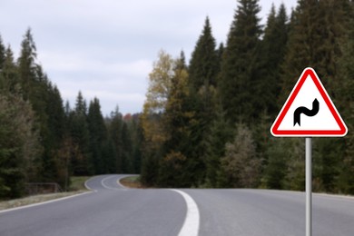 Image of Traffic sign DOUBLE BEND FIRST TO RIGHT near empty asphalt road going through coniferous forest