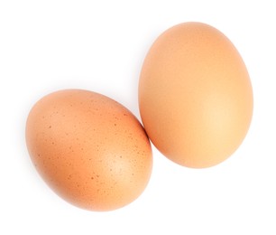 Photo of Two raw chicken eggs isolated on white, top view