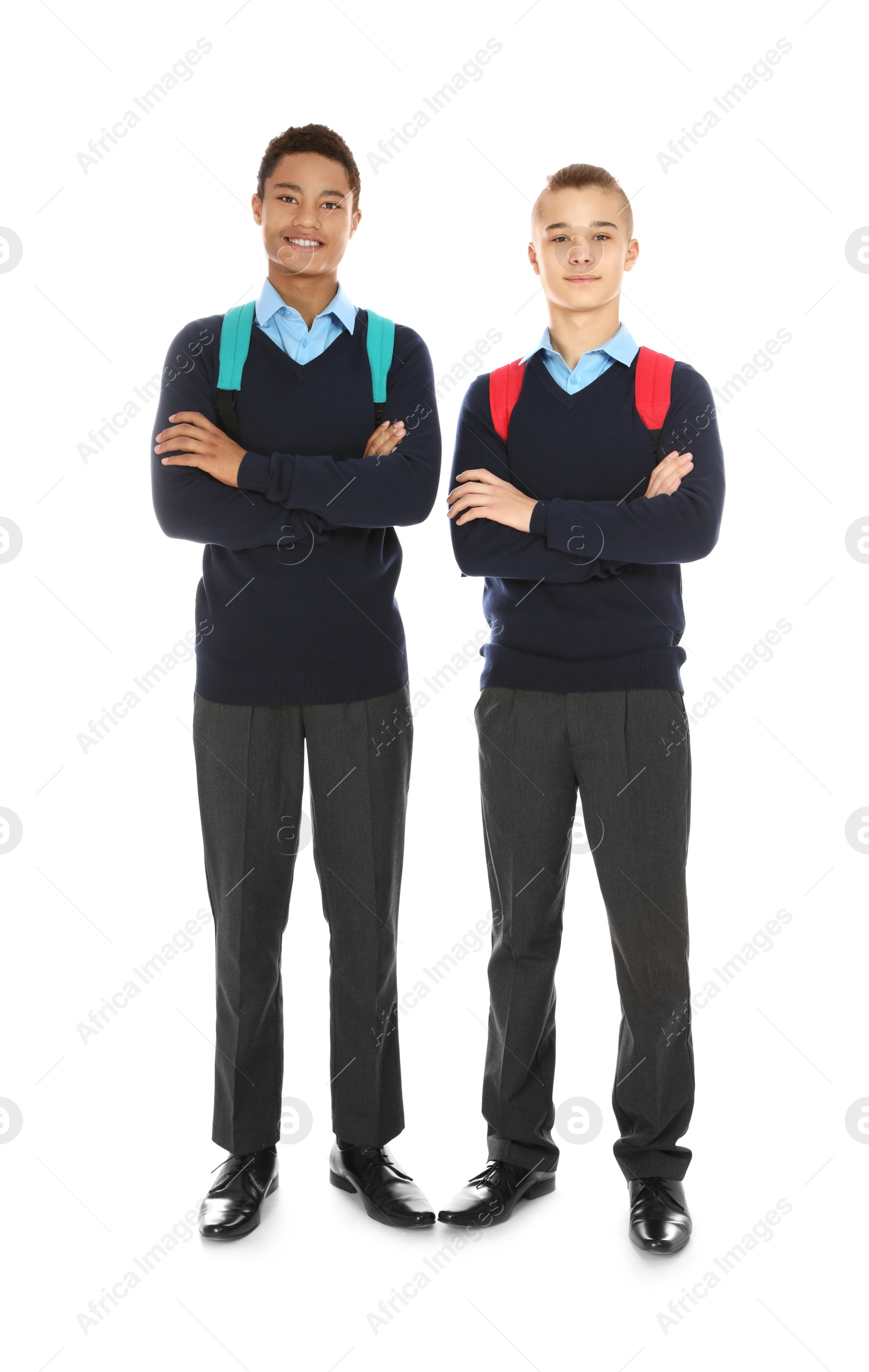 Photo of Full length portrait of teenage boys in school uniform with backpacks on white background