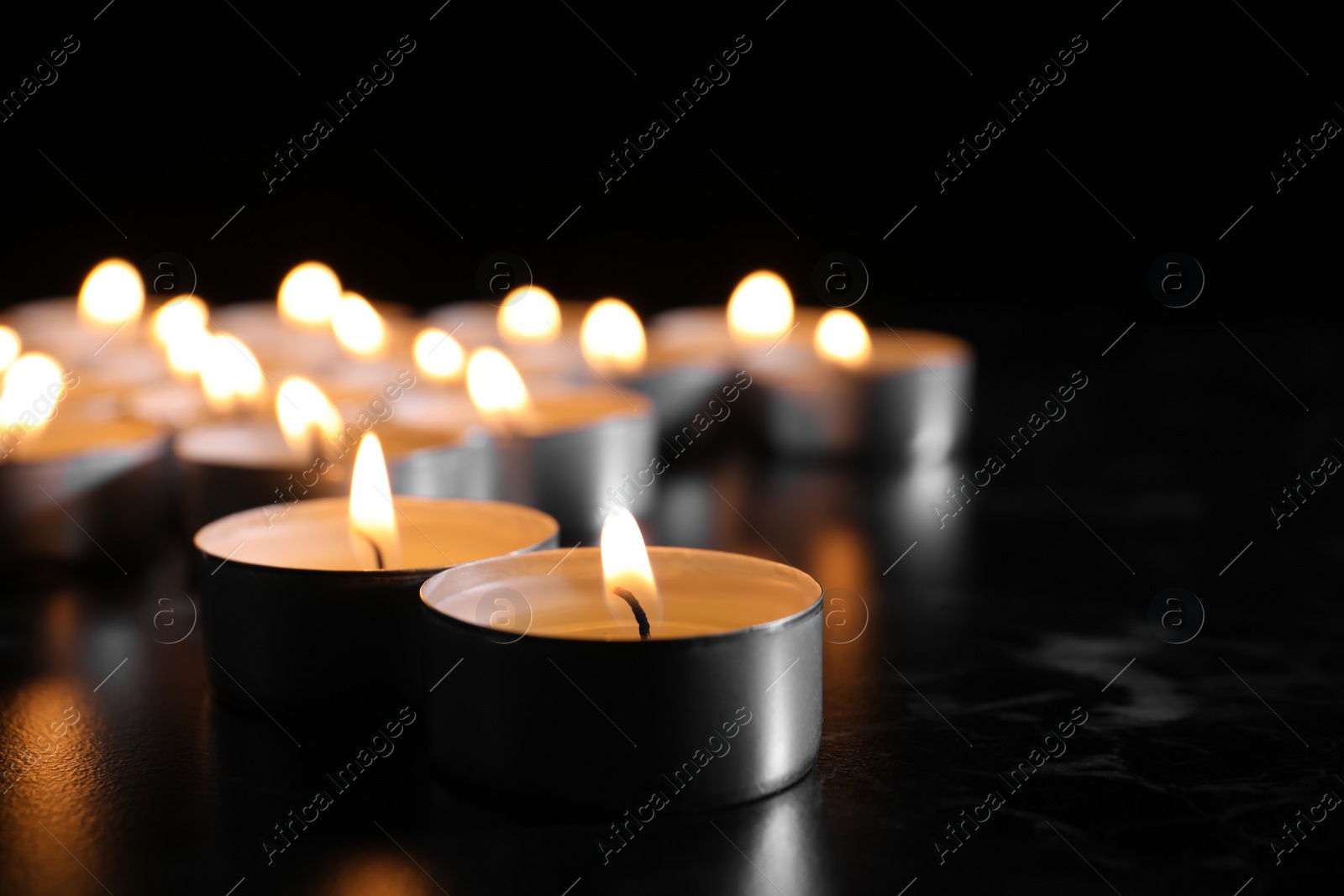 Photo of Burning candles on table in darkness, space for text. Funeral symbol