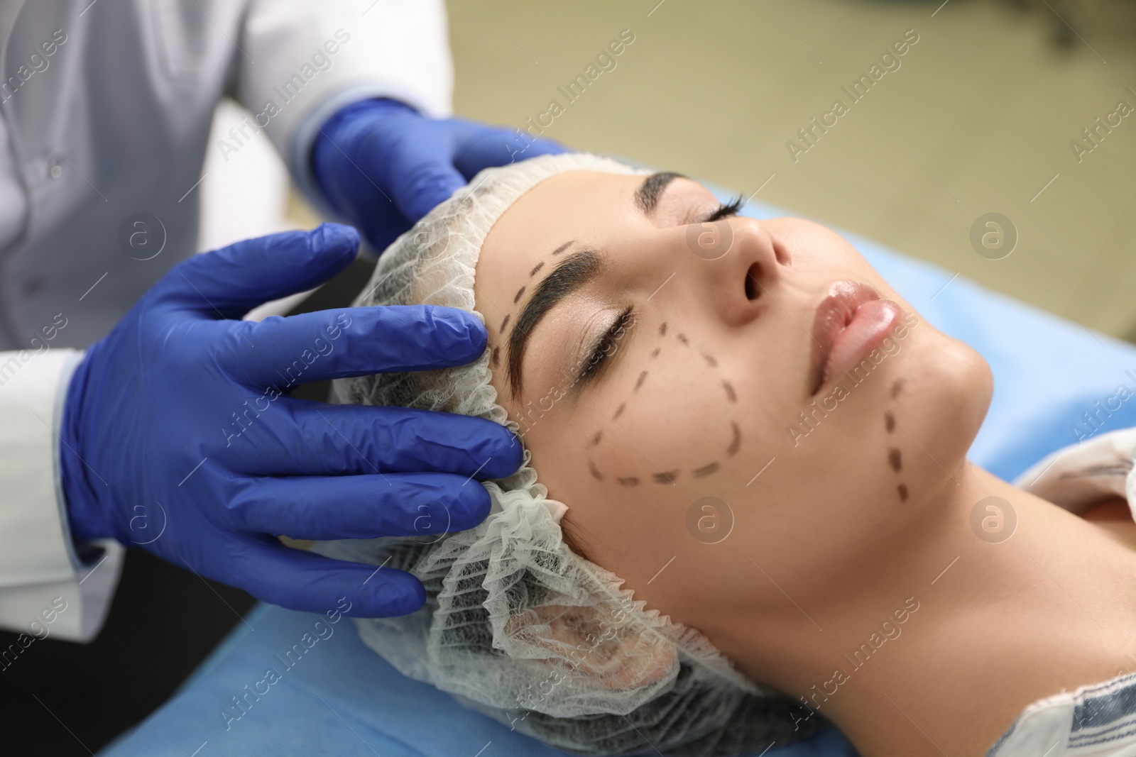 Photo of Doctor preparing female patient for cosmetic surgery in clinic