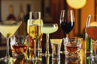 Photo of Different alcohol drinks on table in bar