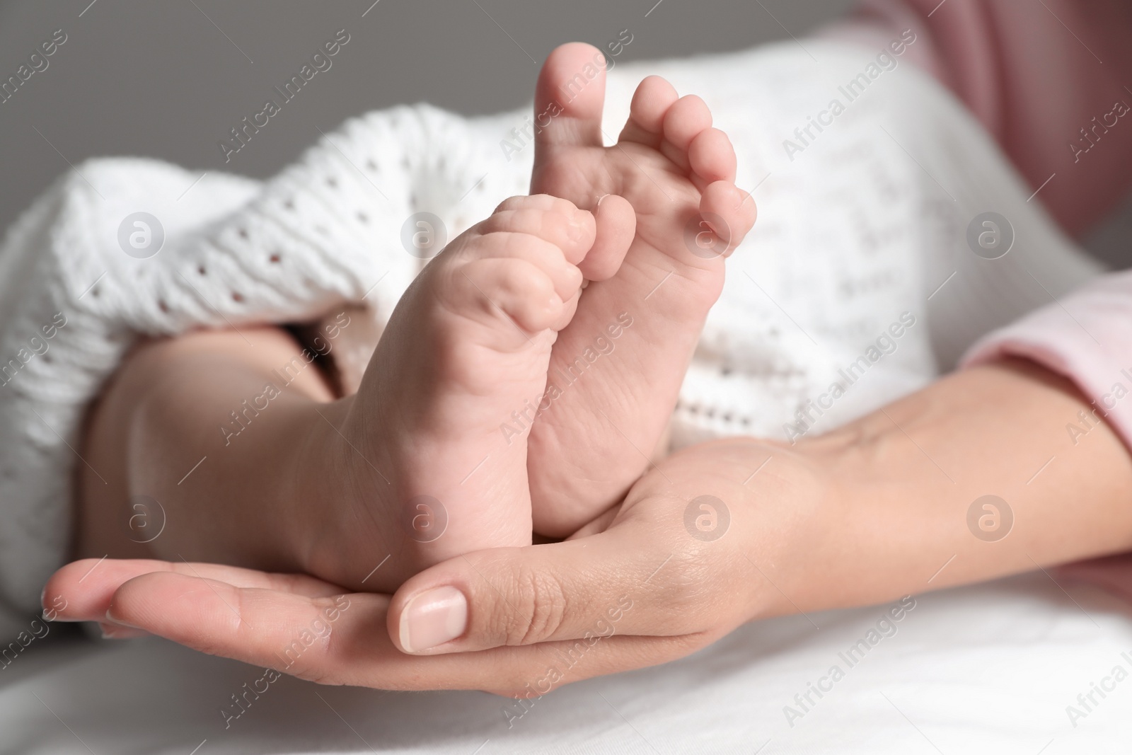 Photo of Mother holding her baby, closeup on feet