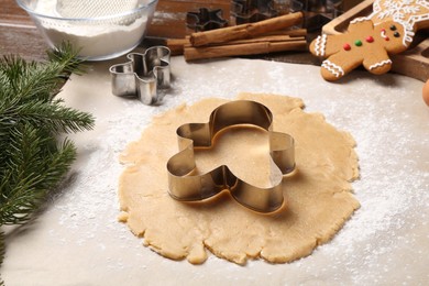 Making Christmas cookies. Raw dough and metal cutter on table