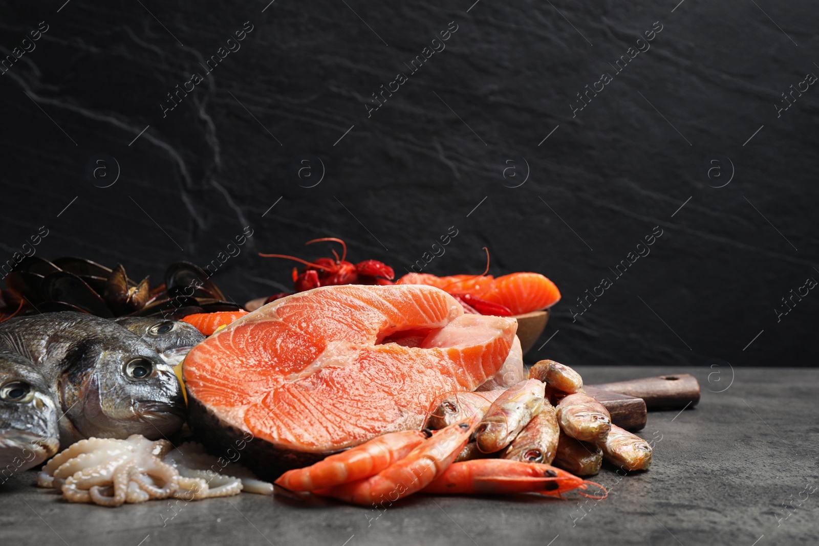 Photo of Fresh fish and different seafood on grey table