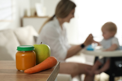 Photo of Mother with her little baby at home, focus on healthy puree and fresh ingredients