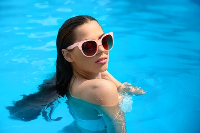 Photo of Beautiful young woman in blue swimming pool