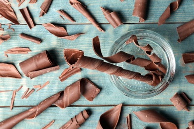 Flat lay composition with chocolate curls on wooden background