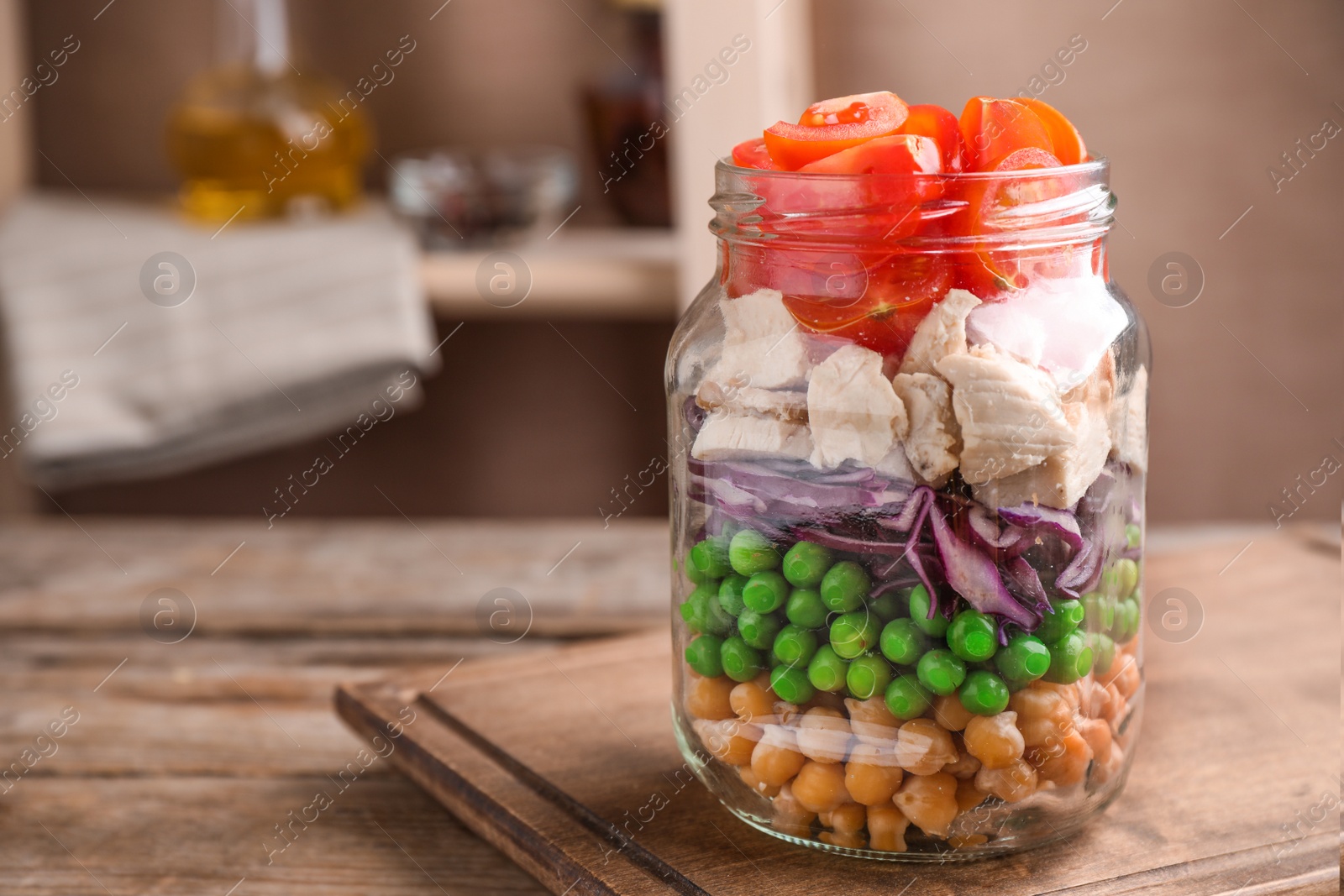 Photo of Healthy salad in glass jar on wooden table. Space for text