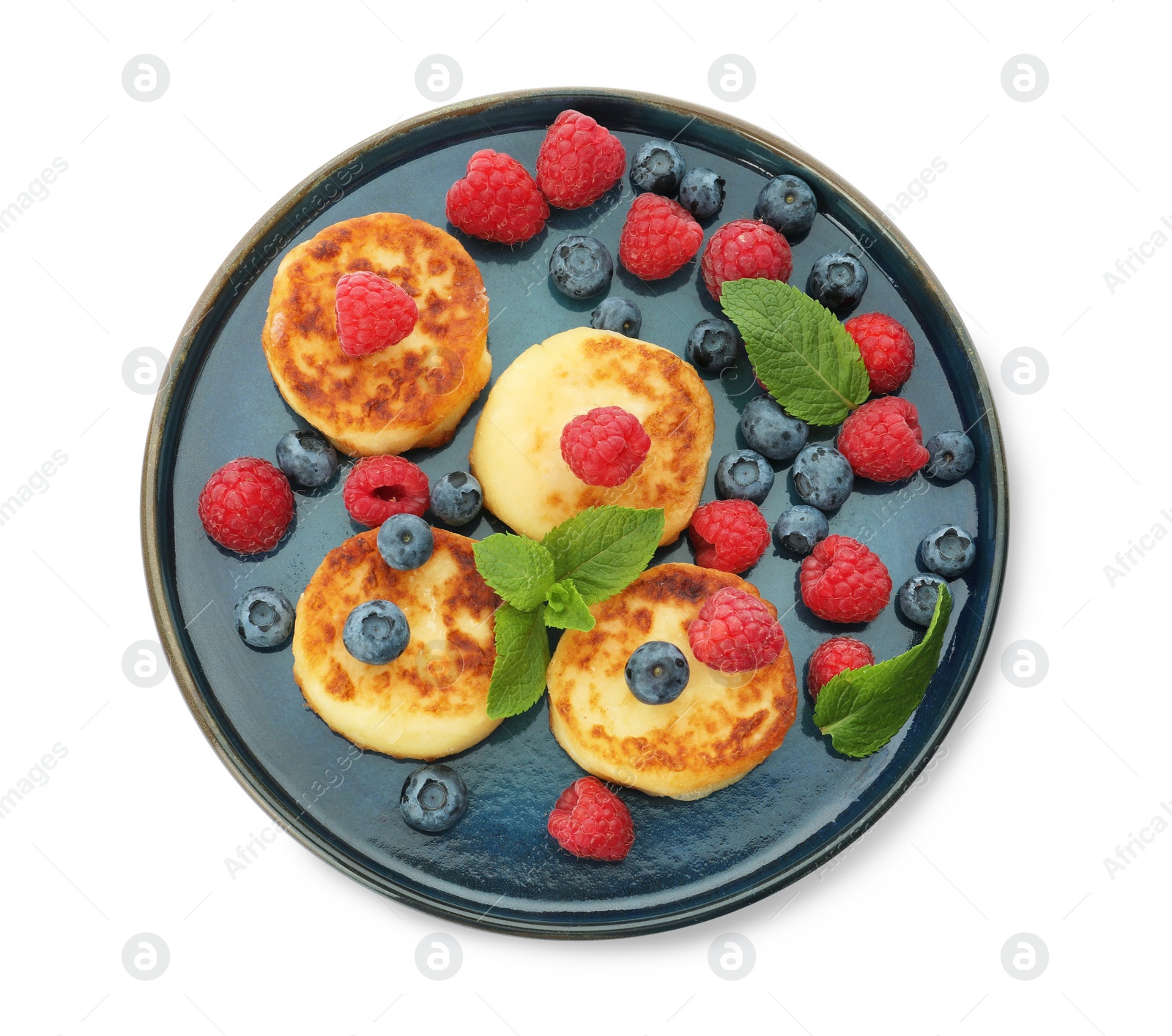 Photo of Plate with delicious cottage cheese pancakes, fresh berries and mint on white background, top view