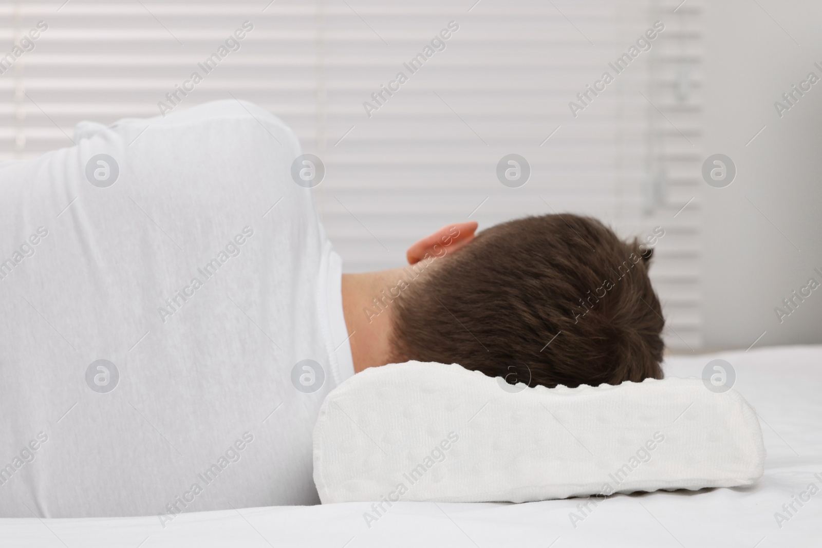 Photo of Man sleeping on orthopedic pillow at home