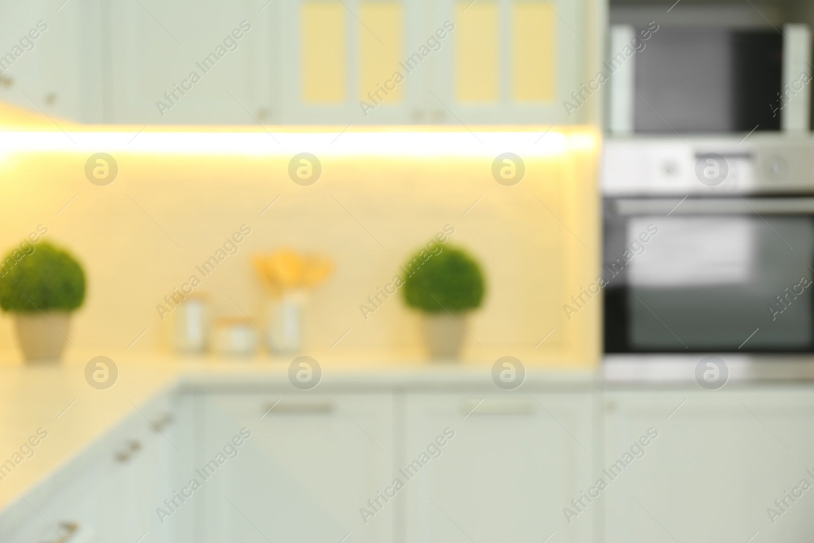 Photo of Blurred view of modern kitchen interior with stylish furniture