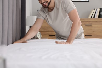 Photo of Man changing bed linens at home, closeup