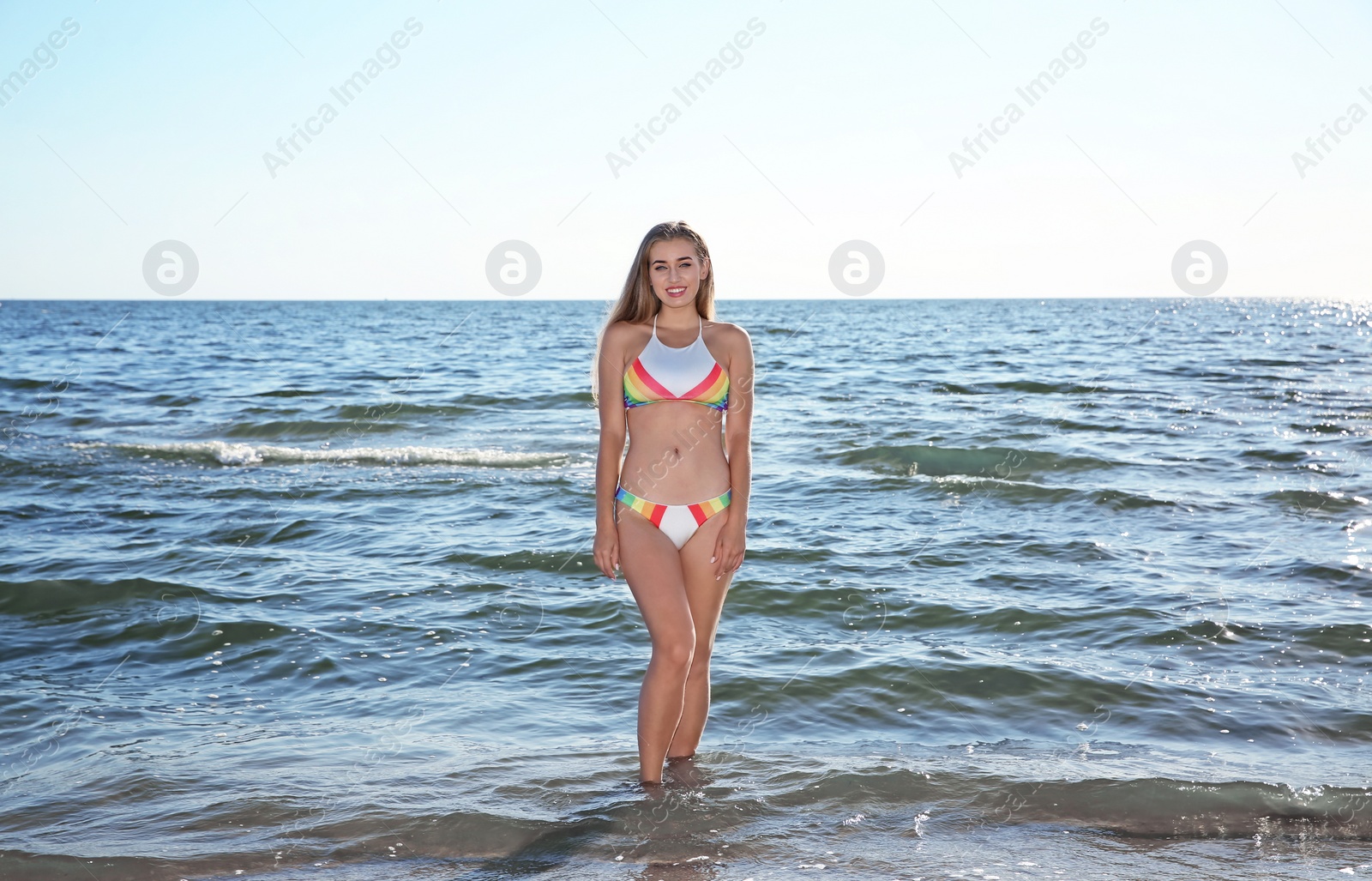 Photo of Beautiful young woman in bikini posing at beach on sunny day