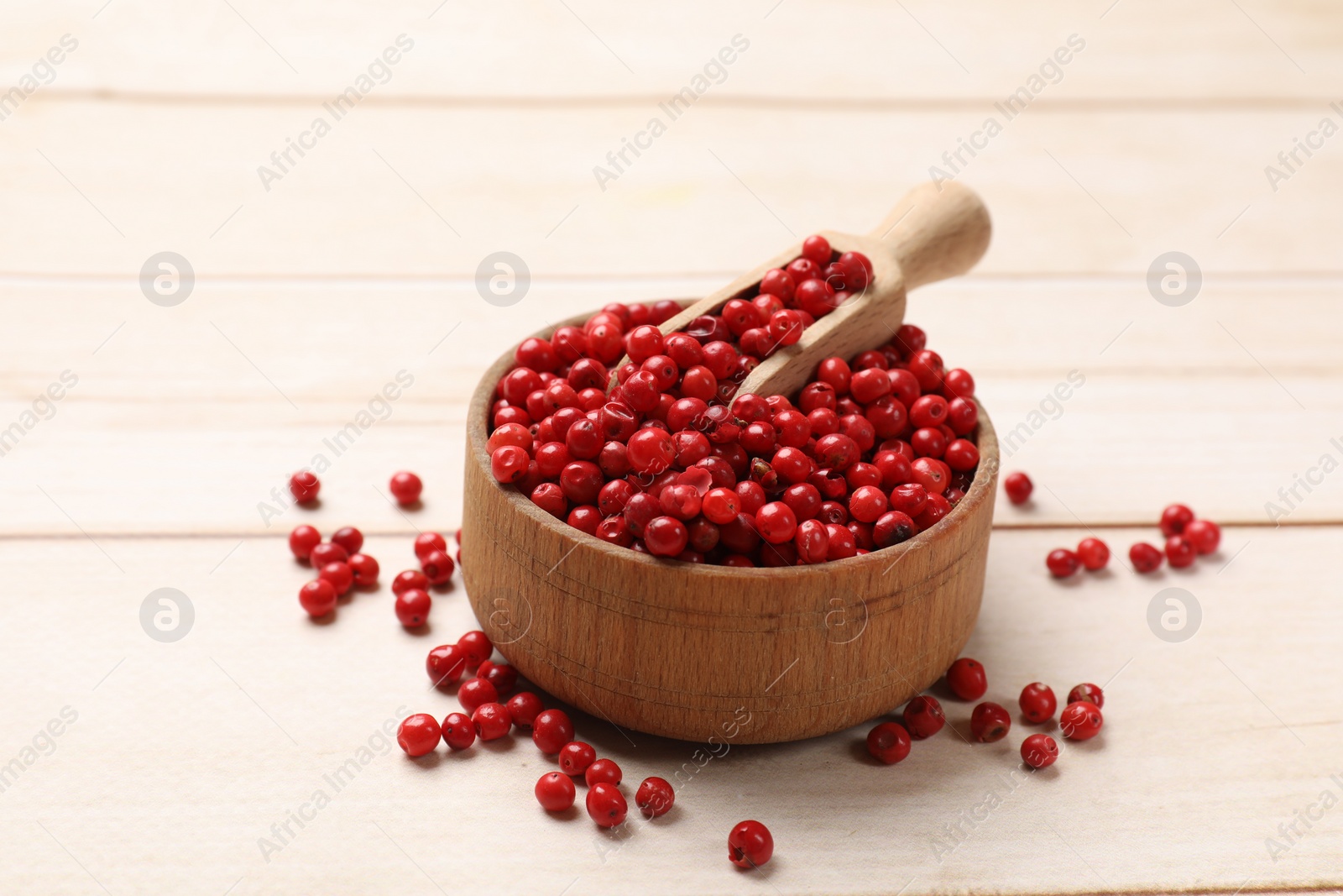 Photo of Aromatic spice. Red pepper in bowl and scoop on white wooden table, closeup