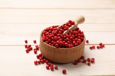 Aromatic spice. Red pepper in bowl and scoop on white wooden table, closeup