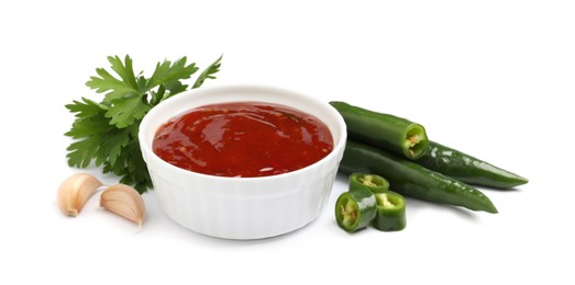 Photo of Spicy chili sauce and ingredients on white background