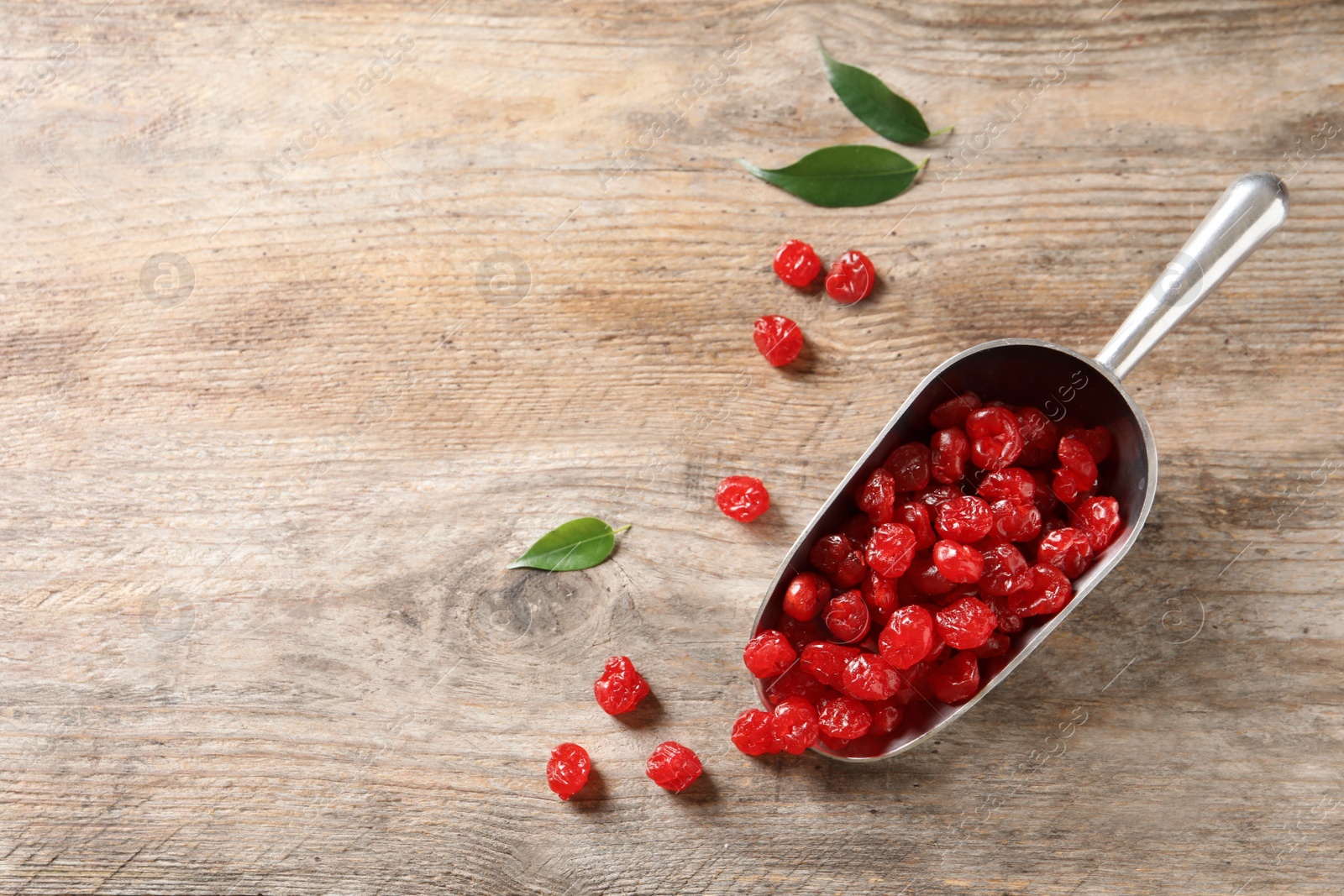 Photo of Scoop of sweet cherries on wooden background, top view with space for text. Dried fruit as healthy snack