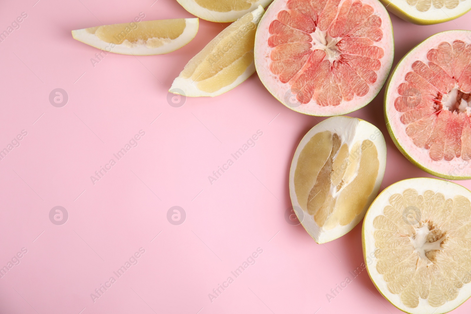 Photo of Fresh cut pomelo fruits on pink background, flat lay. Space for text