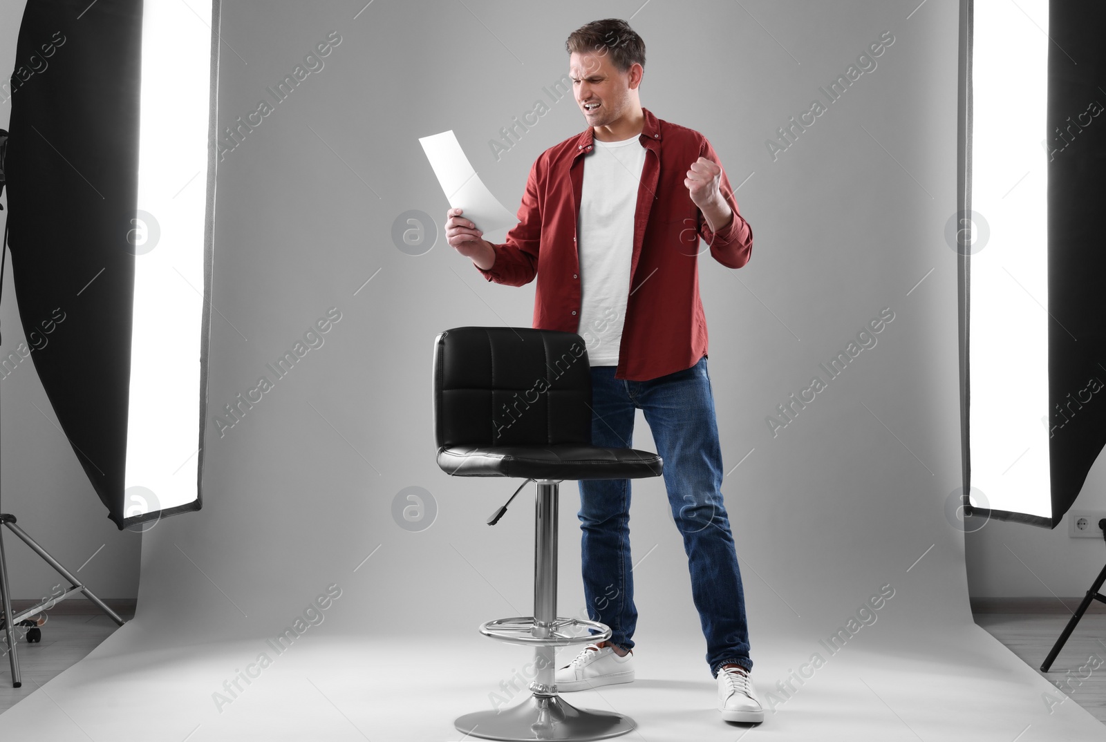 Photo of Casting call. Emotional man with script performing in studio