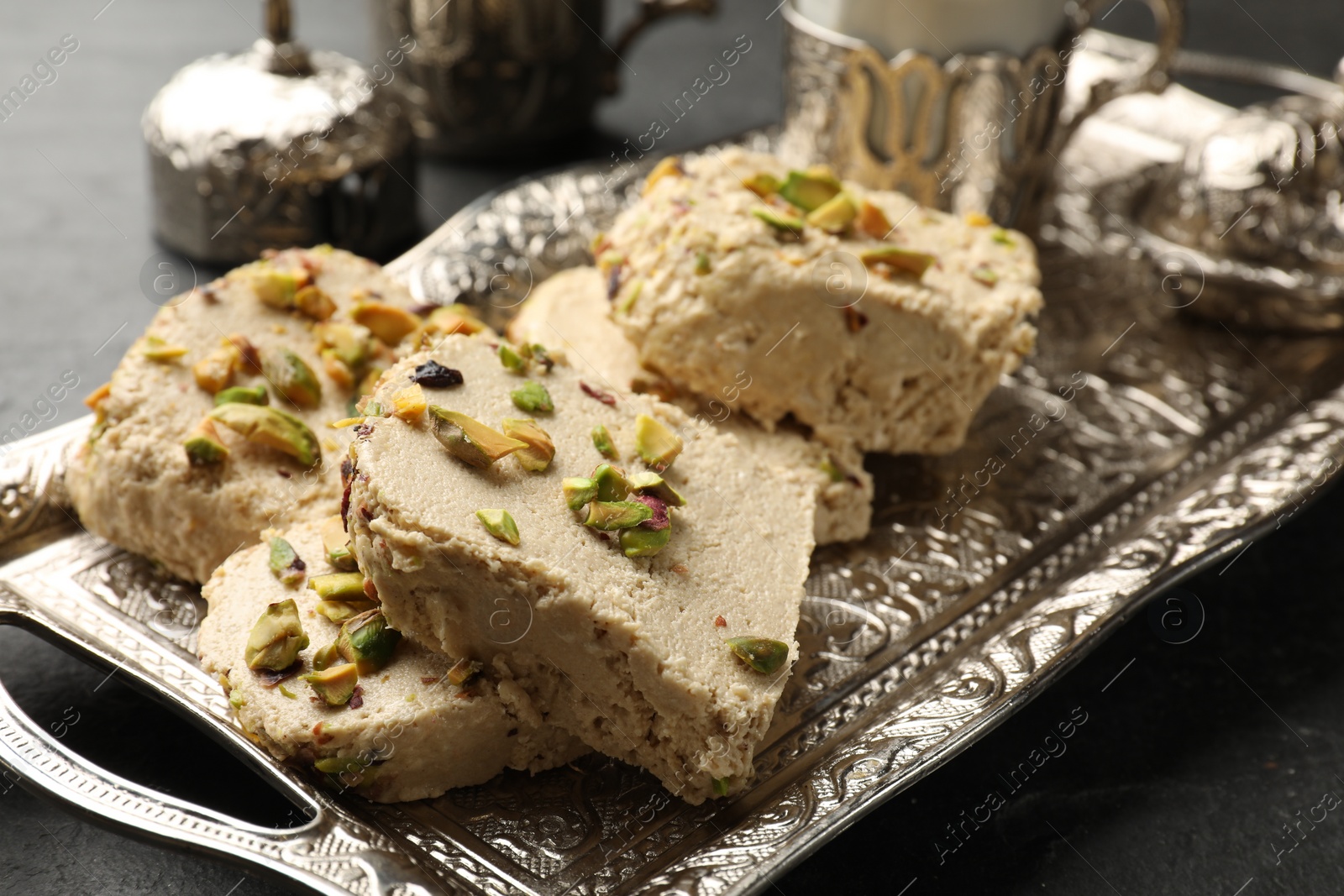 Photo of Tasty pistachio halva on grey table, closeup