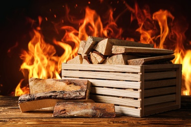 Image of Dry wood and burning fire on background. Cozy atmosphere