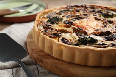 Photo of Delicious quiche with mushrooms and spatula on table, closeup