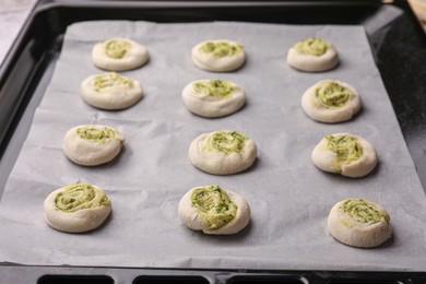 Photo of Raw puff pastry with tasty filling in baking sheet