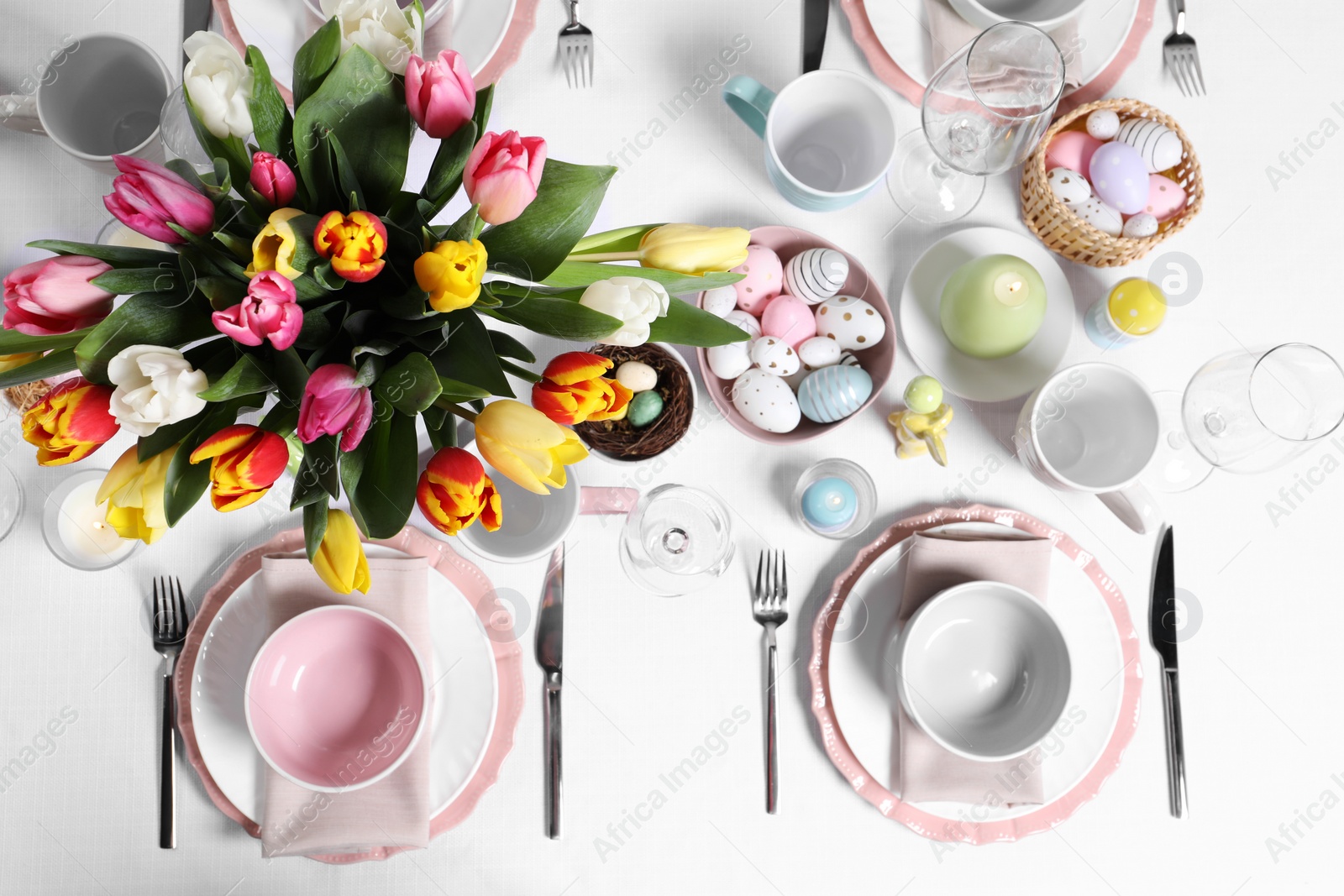 Photo of Festive table setting with beautiful flowers, flat lay. Easter celebration