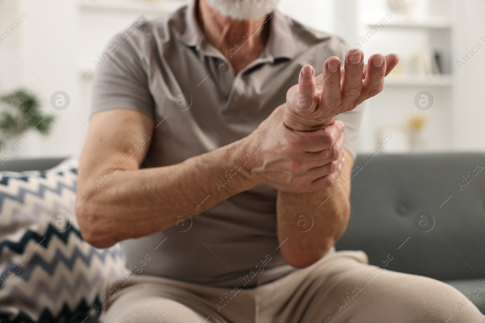 Photo of Arthritis symptoms. Man suffering from pain in wrist at home, closeup