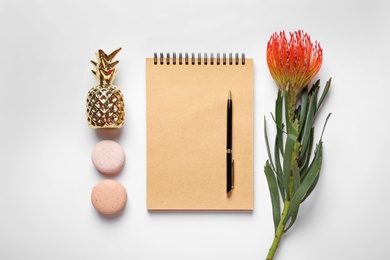 Photo of Creative flat lay composition with tropical flower, notebook and macaroons on white background