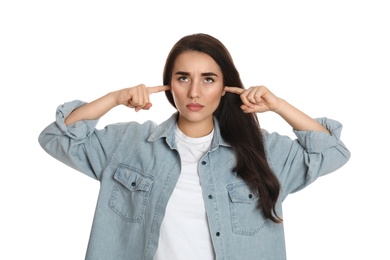 Photo of Young woman covering ears with fingers on white background