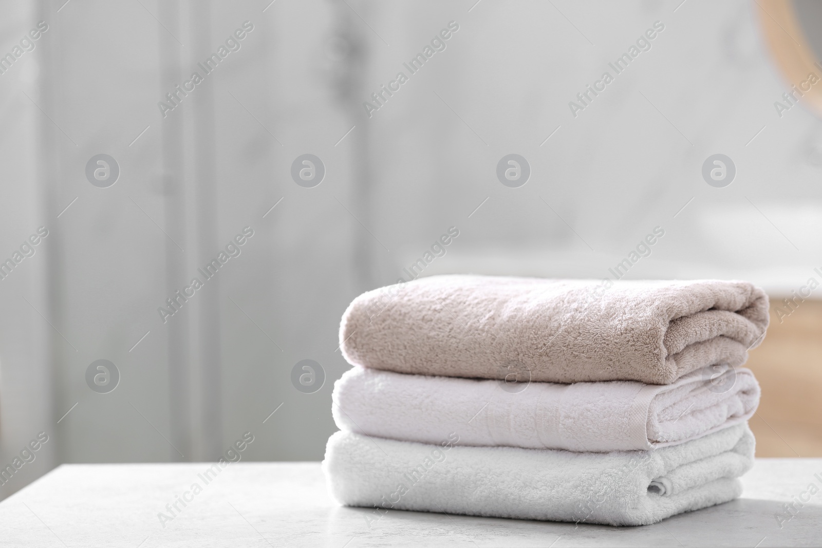 Photo of Stack of clean towels on table in bathroom