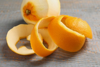 Photo of Peeled fresh orange with zest preparing for drying on wooden table, closeup